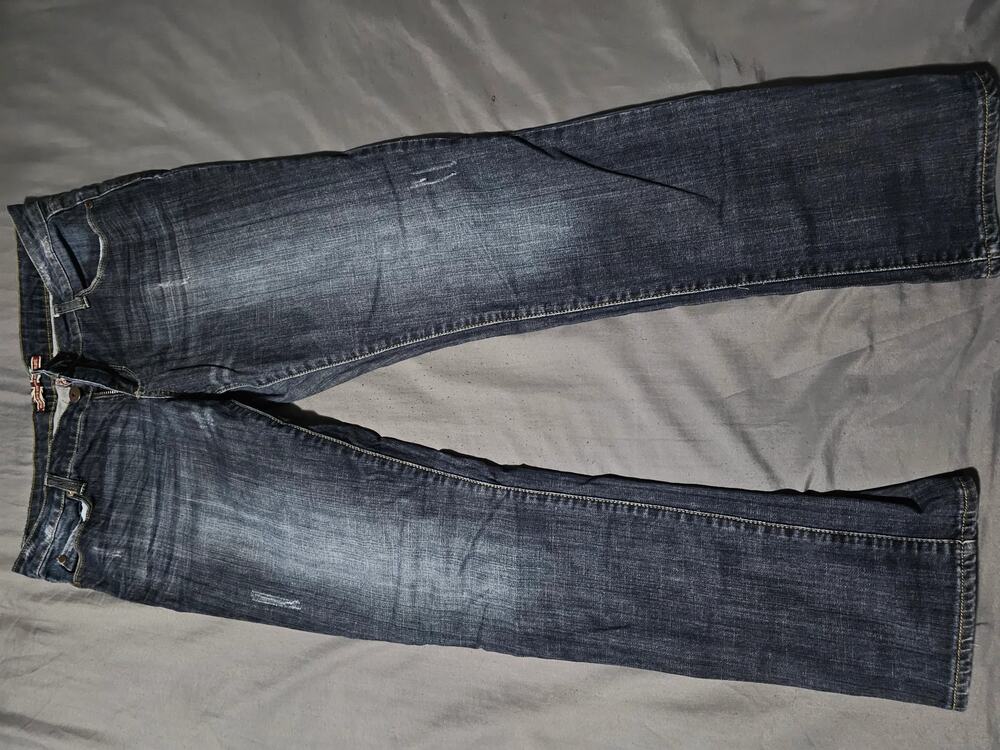 Dark wash denim jeans with faded whiskering and wave stitch back pockets